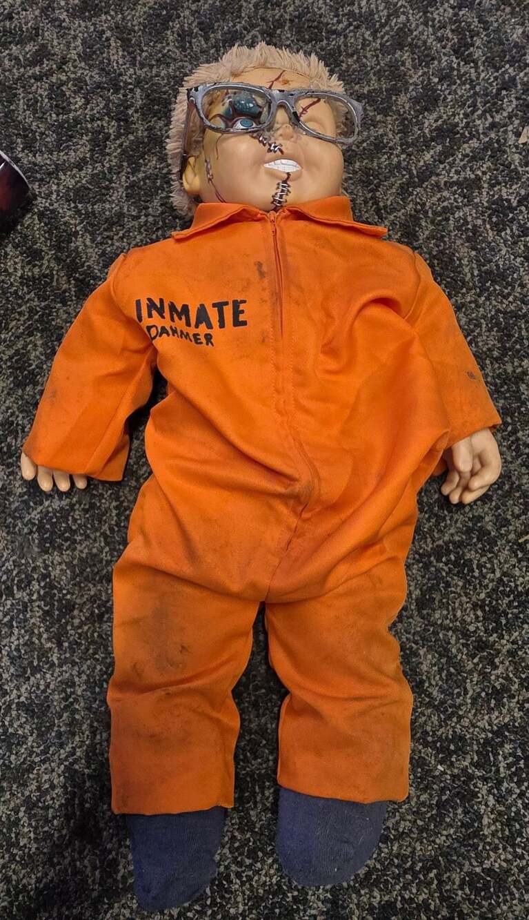Chucky doll turn into  Inmate Dahmer Orange Jumpsuit Doll